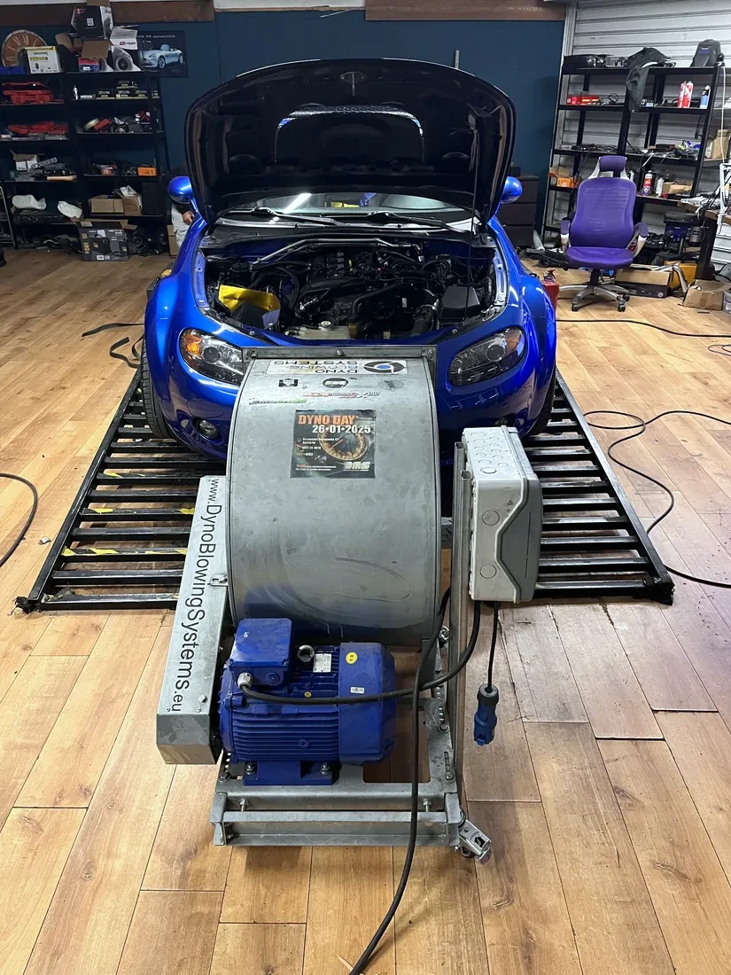 Blue Mazda MX-5 NC on the DMS Tuned dyno, hood open during mapping